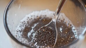 Close-up of hydrated chia seeds in a glass with a spoon scooping the seeds