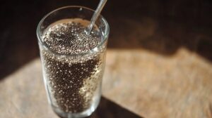 Close-up of a glass filled with chia seeds and water, stirred with a spoon